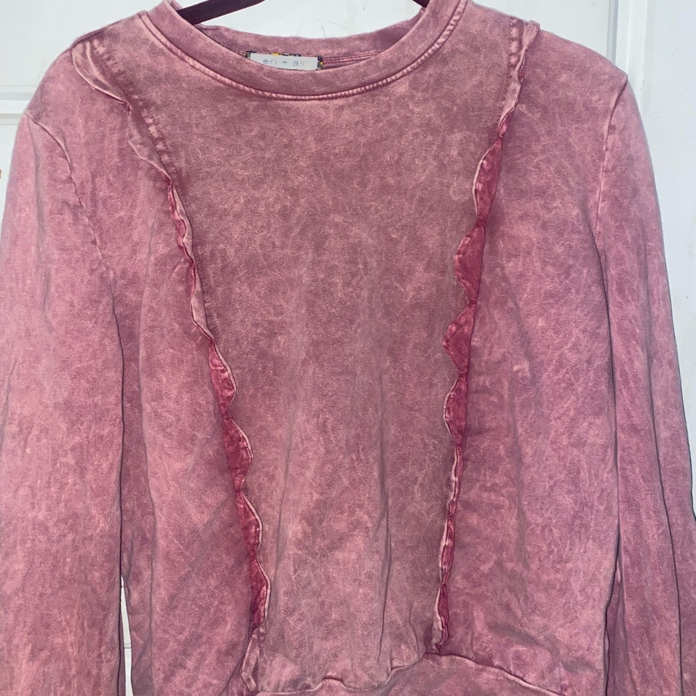 A pink sweater with a marble type pattern (maybe)